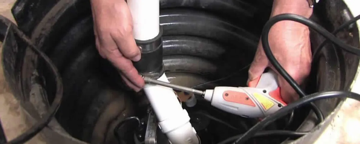 Sump pump installation technician connecting PVC discharge piping in Saint Charles, MO